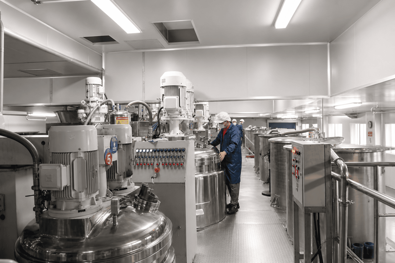 Operator working with stainless-steel mixing equipment in Airsun's compounding room
