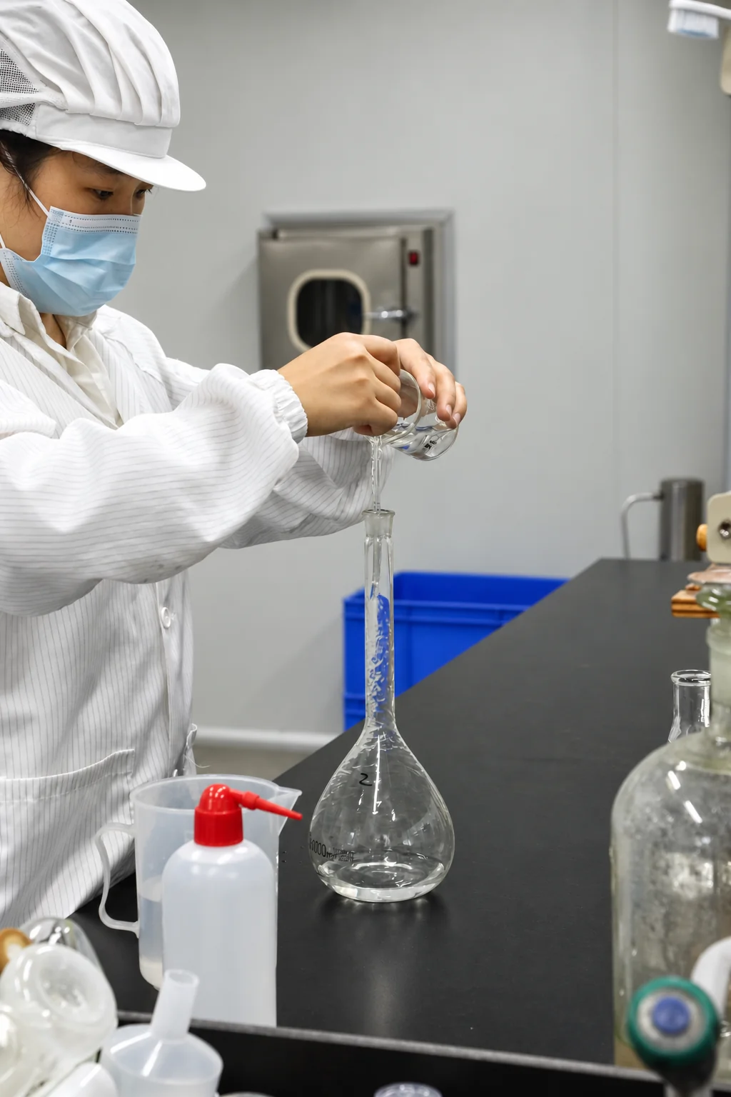 A laboratory technician pouring liquid into a volumetric flask at Airsun.