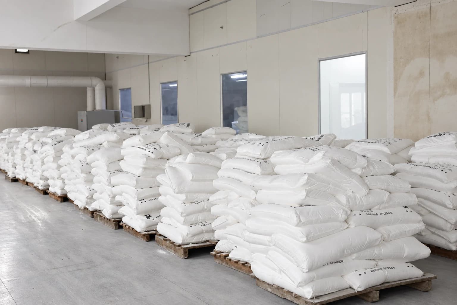 Bagged raw materials stacked on pallets in the Airsun warehouse.